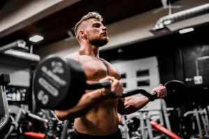 Początkujący sportowiec trzymający butelkę preparatu SARM CORE SARMS na siłowni